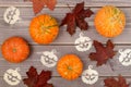 Halloween background of ripe little pumpkins, fallen red maple leaves and stenciled Halloween symbol