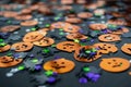 Halloween background: shiny confetti in the shape of orange pumpkins, black spiders and colorful stars