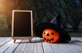 Halloween background. Spooky pumpkin, chalkboard on wooden floor Royalty Free Stock Photo