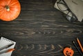 Halloween background, top view. Pumpkin and school supplies on dark wooden table, flat lay Royalty Free Stock Photo