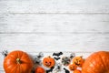 Halloween background, top view. Pumpkins and sweets on white wooden table, flat lay Royalty Free Stock Photo