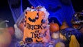 Halloween bag full of candies and sweets. Trick or treat, Halloween spooky scenery with pumpkins, misty fog, candies, skull