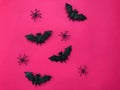 Halloween bats and spiders on pink background.
