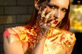 Halloween beauty Witch girl portrait with golden make-up. Glitter metallic shine golden make-up. Burning woman golden