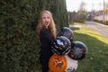 Halloween. A blonde girl with long beautiful hair holds beautiful orange, black and white balloons in her hands