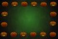 A Halloween border of pumpkin faces with orange and yellow cut-out features, on a dark green vignette background