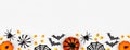 Halloween bottom border banner flat lay of pumpkins, candy and decor, over a white background Royalty Free Stock Photo