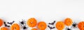 Halloween bottom border of orange pumpkins with black bats and spiders over a white banner background Royalty Free Stock Photo