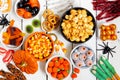 Halloween candy buffet table scene over a white wood background