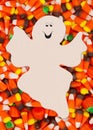 Halloween candy corn background with spooky ghost for your message