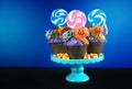 Halloween candyland drip cake style cupcakes with candy on blue background. Royalty Free Stock Photo