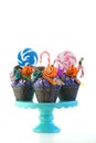 Halloween candyland drip cake style cupcakes with lollipops and candy on white. Royalty Free Stock Photo