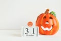 Halloween card with copy space for congratulation. Calendar dated October 31 and Jack-o-latern on white table. Selective