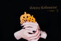 Halloween card. Happy Halloween. Female hands holding funny little pumpkins on black background. Manicure with black nail polish Royalty Free Stock Photo