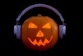 Halloween Carved Pumpkin Lantern with Headphones on a Black Background Royalty Free Stock Photo