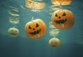 Halloween carved pumpkins submerged underwater.