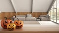 Halloween carved pumpkins on wooden table. Autumn decoration over interior design scene. Modern minimal mansard mezzanine living Royalty Free Stock Photo