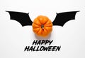 Halloween celebration message concept. Orange colored mini pumpkin over white background with bat wings with the message happy Royalty Free Stock Photo