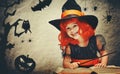 Halloween. cheerful little witch with magic wand and book conjur