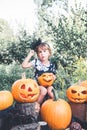 Halloween. Child dressed in black with jack-o-lantern in hand, trick or treat. Little girl pumpkin in the wood, outdoors. Toned p