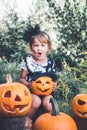 Halloween. Child dressed in black with jack-o-lantern in hand, trick or treat. Little girl pumpkin in the wood, outdoors. Wow. To