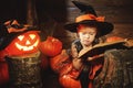 Halloween. child little witch with pumpkin Jack and magical bo Royalty Free Stock Photo