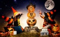 Halloween.The children of witches and wizards conjure over the pumpkin. Royalty Free Stock Photo