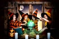 Halloween.The children of witches and wizards cooking potion in the cauldron with pumpkin and spell book. Royalty Free Stock Photo