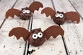 Halloween chocolate donut hole bats against white wood