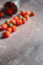 Halloween-colored pumpkin-shaped candy canes are placed on a gray table with sunlight in the background Royalty Free Stock Photo