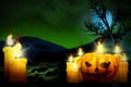 Halloween colorful horror dark backdrop - set of candles on left side and candle in pumpkin style on right, trick or treat concept Royalty Free Stock Photo