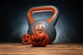 Halloween composition with ceramic Jack Lantern pumpkins and gym kettlebell. Royalty Free Stock Photo