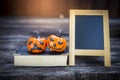 Funny halloween pumpkin on old book with chalkboard with space on wood background Royalty Free Stock Photo