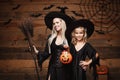 Halloween Concept - beautiful caucasian mother and her daughter in witch costumes celebrating Halloween with sharing Halloween can Royalty Free Stock Photo