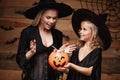 Halloween Concept - beautiful caucasian mother and her daughter in witch costumes celebrating Halloween with sharing Halloween can Royalty Free Stock Photo