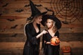 Halloween Concept - beautiful caucasian mother and her daughter in witch costumes celebrating Halloween with sharing Halloween can Royalty Free Stock Photo