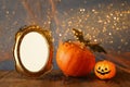 Halloween concept. Cute pumpkin next to blank photo frame Royalty Free Stock Photo