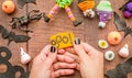 Female hands with black nails making halloween cupcake craft on wooden table top view Royalty Free Stock Photo