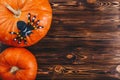 Halloween concept with fresh pumpkins and a spider on it on the wooden table. Trick or Treat view from above