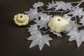 Halloween concept. Ghostly white maple leaves on a branch, pumpkins Royalty Free Stock Photo