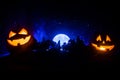 Halloween concept with glowing pumpkins. Strange silhouette in a dark spooky forest at night, mystical landscape surreal lights wi Royalty Free Stock Photo