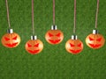 Halloween concept on hanging abstract pumpkins on a background of green grass