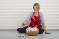 A woman artist prepares for halloween and paints pumpkins Royalty Free Stock Photo