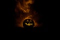 Halloween concept. Jack-o-lantern smile and scary eyes for party night. Close up view of scary pumpkin with witch hat on at dark f Royalty Free Stock Photo