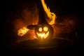 Halloween concept. Jack-o-lantern smile and scary eyes for party night. Close up view of scary pumpkin with witch hat on at dark f Royalty Free Stock Photo