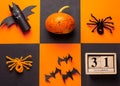 Halloween concept. Pumpkin, paper cut bats, spiders, wood calendar with date 31 october on the black and orange background. Ideas Royalty Free Stock Photo