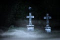 Halloween concept, stone crosses at night on the foggy cemetery Royalty Free Stock Photo