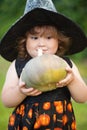 Funny little witch with pumpkin.