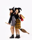 Halloween concept, young asian women wearing witch hat holding broom and shopping bags posing on white background Royalty Free Stock Photo