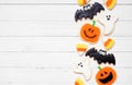 Halloween cookie side border on a white wood background